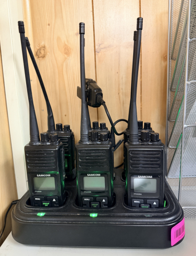 (6) SAMCOM WALKIE TALKIES W/ CHARGING BASE.