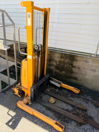 ULINE ELECTRIC STRADDLE STACKER WITH POWER LIFT AND POWER DRIVE FUNCTIONS. WALK-BEHIND DESIGN WITH STRADDLE LEGS, FORKS, BATTERY COMPARTMENT, SAFETY GUARDING, AND OPERATOR CONTROLS.