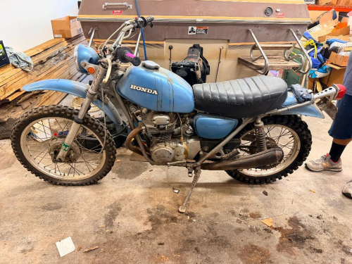 HONDA VINTAGE DUAL SPORT MOTORCYCLE. SINGLE-CYLINDER AIR-COOLED ENGINE WITH MANUAL TRANSMISSION, SPOKED WHEELS, FRONT AND REAR DRUM BRAKES, HIGH-MOUNT EXHAUST, HEADLIGHT, TURN SIGNALS, AND REAR TAILLIGHT. MOTORCYCLE SHOWS AGE-RELATED WEAR, PAINT FADING, S
