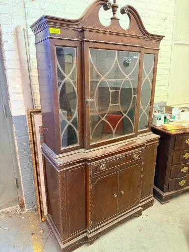 TRADITIONAL CHINA CABINET/HUTCH FEATURING A TWO-PIECE DESIGN WITH GLAZED DISPLAY DOORS, DECORATIVE MUNTIN PATTERN GLASS PANELS, LOWER STORAGE CABINET, AND SINGLE CENTER DRAWER. CONSTRUCTED OF WOOD WITH A DARK FINISH AND DECORATIVE CROWN PEDIMENT.