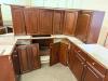 DARK CHERRY FINISH KITCHEN CABINET SET CONSISTING OF MULTIPLE WALL CABINETS, BASE CABINETS, CORNER CABINET SECTIONS, DRAWER BASES, AND APPLIANCE SURROUND CABINETRY. FEATURES RAISED PANEL DOORS AND MATCHING FINISH THROUGHOUT. - 2