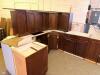 DARK CHERRY FINISH KITCHEN CABINET SET CONSISTING OF MULTIPLE WALL CABINETS, BASE CABINETS, CORNER CABINET SECTIONS, DRAWER BASES, AND APPLIANCE SURROUND CABINETRY. FEATURES RAISED PANEL DOORS AND MATCHING FINISH THROUGHOUT. - 5