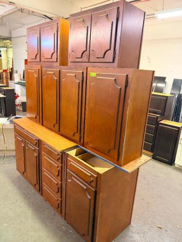 TRADITIONAL KITCHEN CABINET SET CONSISTING OF MULTIPLE WALL CABINETS, BASE CABINETS, DRAWER BASE UNITS, AND STORAGE CABINET SECTIONS. FEATURES DECORATIVE RAISED PANEL DOORS WITH ROUTED EDGE DETAILS AND A MEDIUM CHERRY STAIN FINISH.
