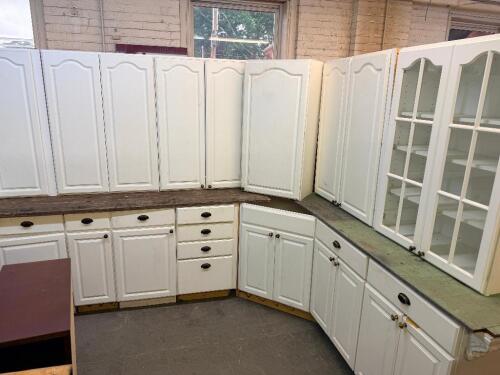 WHITE PAINTED KITCHEN CABINET SET CONSISTING OF MULTIPLE WALL CABINETS, BASE CABINETS, CORNER CABINET SECTIONS, GLASS-FRONT DISPLAY CABINETS, DRAWER BASES, AND WOOD COUNTERTOP SECTIONS. FEATURES RAISED PANEL DOORS AND DECORATIVE HARDWARE THROUGHOUT.