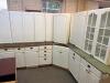 WHITE PAINTED KITCHEN CABINET SET CONSISTING OF MULTIPLE WALL CABINETS, BASE CABINETS, CORNER CABINET SECTIONS, GLASS-FRONT DISPLAY CABINETS, DRAWER BASES, AND WOOD COUNTERTOP SECTIONS. FEATURES RAISED PANEL DOORS AND DECORATIVE HARDWARE THROUGHOUT.