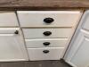 WHITE PAINTED KITCHEN CABINET SET CONSISTING OF MULTIPLE WALL CABINETS, BASE CABINETS, CORNER CABINET SECTIONS, GLASS-FRONT DISPLAY CABINETS, DRAWER BASES, AND WOOD COUNTERTOP SECTIONS. FEATURES RAISED PANEL DOORS AND DECORATIVE HARDWARE THROUGHOUT. - 6