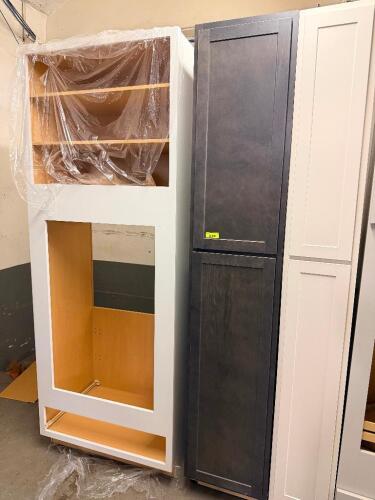 WHITE SHAKER-STYLE OVEN CABINET ASSEMBLY WITH OPEN UPPER STORAGE COMPARTMENT, LARGE CENTER APPLIANCE OPENING, AND MATCHING TALL SINGLE-DOOR PANTRY CABINET IN A DARK CHARCOAL FINISH.