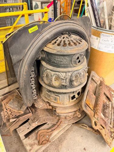 ANTIQUE CAST IRON PARLOR STOVE WITH ORNATE FIREPLACE SURROUND AND ASSORTED RESTORATION PARTS.