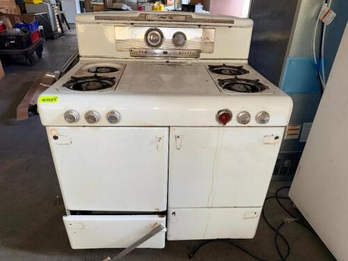VINTAGE MAGIC CHEF FREESTANDING GAS RANGE WITH FOUR OPEN BURNERS, PORCELAIN ENAMELED FINISH, BUILT-IN OVEN, MECHANICAL CONTROLS, CLOCK, AND MAGIC AIRE TEMPERATURE INDICATOR. UNIT SHOWS AGE-RELATED WEAR AND IS BEING SOLD IN AS-IS CONDITION.