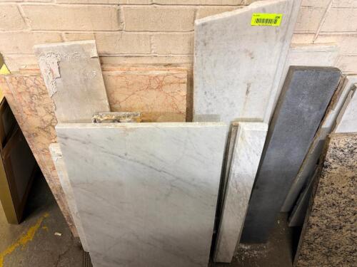 ASSORTED NATURAL STONE SLABS AND REMNANTS INCLUDING MARBLE, GRANITE, AND OTHER POLISHED STONE PIECES.