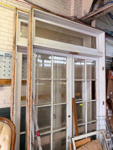 ANTIQUE WOOD FRENCH DOOR ENTRY ASSEMBLY WITH MATCHING SIDE LITES, TRANSOM WINDOW, AND ORIGINAL WOOD FRAME. ASSEMBLY FEATURES MULTI-PANE GLASS DOORS, FULL-LENGTH SIDE LITES, AND A FIXED TRANSOM WITH ORIGINAL PAINTED FINISH.