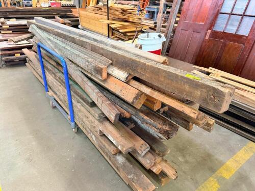 LOT OF RECLAIMED HEAVY TIMBERS AND STRUCTURAL LUMBER. LOT INCLUDES ASSORTED SOLID WOOD BEAMS, POSTS, AND DIMENSIONAL LUMBER IN VARIOUS LENGTHS AND CROSS SECTIONS SUITABLE FOR REUSE, TIMBER FRAMING, OR DECORATIVE PROJECTS. CART IS NOT INCLUDED.