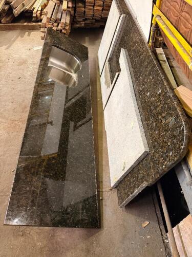 (2) 8' SECTIONS OF GRANITE COUNTERTOPS WITH INTEGRATED STAINLESS STEEL SINKS. LOT INCLUDES MULTIPLE POLISHED GRANITE COUNTERTOP SECTIONS, INCLUDING ONE LARGE DOUBLE-BOWL SINK TOP, MATCHING BACKSPLASHES, AND ADDITIONAL GRANITE REMNANTS.