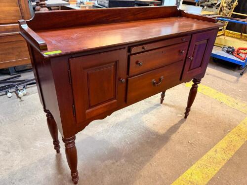 KINCAID SOLID WOOD SERVER / SIDEBOARD BUFFET. FEATURES A RAISED BACKSPLASH, TWO SIDE CABINETS, THREE CENTER DRAWERS, TURNED LEGS, AND A RICH CHERRY FINISH.