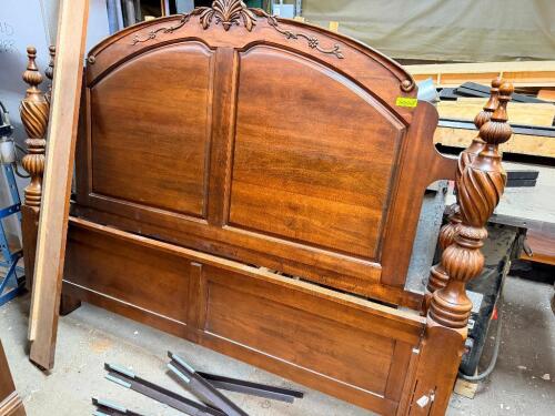 ORNATE WOOD KING-SIZE BED FRAME. FEATURES A CARVED ARCHED HEADBOARD, DECORATIVE FLORAL CREST, HEAVILY TURNED POSTS, AND A MATCHING PANEL FOOTBOARD IN A WARM CHERRY FINISH