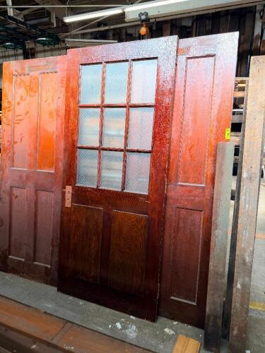 THREE SOLID WOOD INTERIOR DOORS INCLUDING A 9-LITE GLASS DOOR WITH WIRED/OBSCURE GLASS PANEL AND TWO MATCHING FOUR-PANEL DOORS. IDEAL FOR HISTORIC RESTORATION