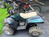 SMALLER GAS-POWERED SPORT ATV WITH AUTOMATIC TRANSMISSION, FRONT AND REAR SUSPENSION, FRONT BUMPER, KNOBBY OFF-ROAD TIRES, AND MOLDED PLASTIC BODY PANELS