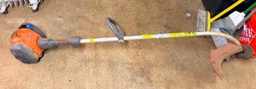 GAS-POWERED STRING TRIMMER WITH CURVED SHAFT, LOOP HANDLE, TRIMMER HEAD, AND DEBRIS GUARD.