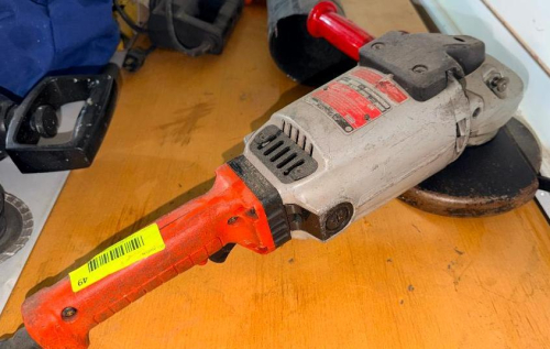 HEAVY-DUTY ANGLE GRINDER WITH SIDE HANDLE AND INSTALLED GRINDING WHEEL.