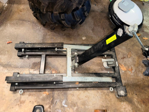 HEAVY-DUTY MOTORCYCLE/ATV HYDRAULIC SERVICE LIFT WITH FOOT-OPERATED HYDRAULIC PUMP, FOUR SWIVEL CASTERS, AND STEEL LIFTING PLATFORM.