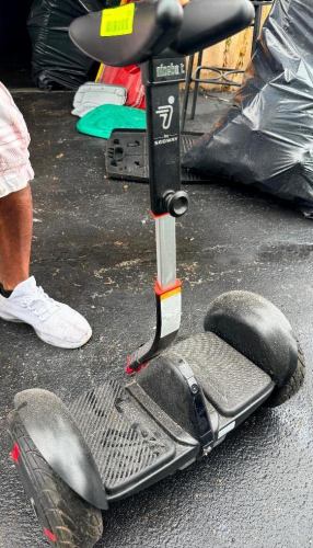 SEGWAY SELF-BALANCING PERSONAL TRANSPORTER WITH KNEE CONTROL BAR, DUAL WHEELS, AND RECHARGEABLE BATTERY SYSTEM.
