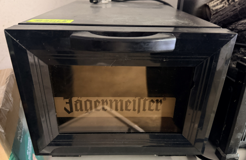 J&Auml;GERMEISTER COUNTERTOP SHOT GLASS CHILLER WITH GLASS DOOR AND INTERIOR BOTTLE STORAGE. INCLUDES POWER CORD.