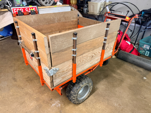 GAS-POWERED UTILITY WAGON WITH WOOD CARGO BED, STEEL FRAME, AND PNEUMATIC TIRES.