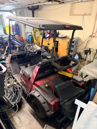 GAS GOLF CART WITH REAR FLIP SEAT, CANOPY TOP, AND WINDSHIELD.
