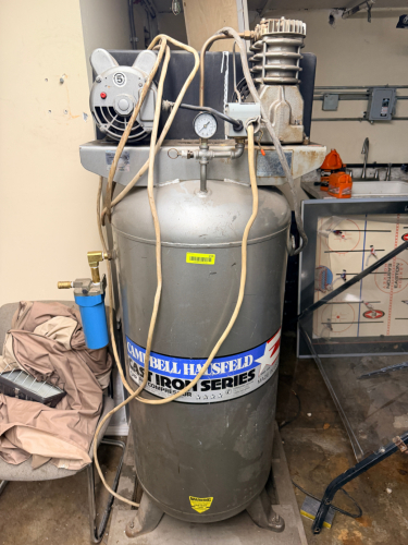 VERTICAL AIR COMPRESSOR WITH CAST IRON TWIN CYLINDER PUMP, BELT DRIVE SYSTEM, INTEGRATED PRESSURE GAUGE, AIR REGULATOR, AND INLINE AIR FILTER.