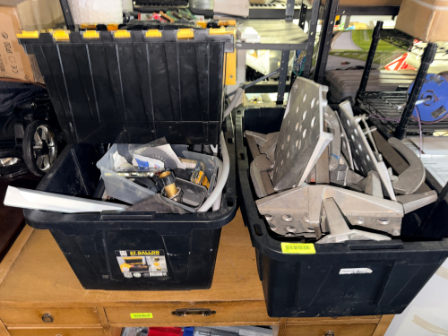 (2) BLACK PLASTIC TOTES W/ CONTENTS - ASSORTED HARDWARE AND TOOLING.