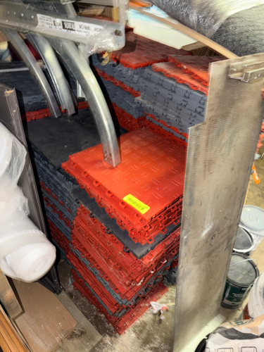 LOT OF INTERLOCKING MODULAR FLOOR TILES WITH RED AND GRAY DIAMOND PLATE SURFACE PATTERN.