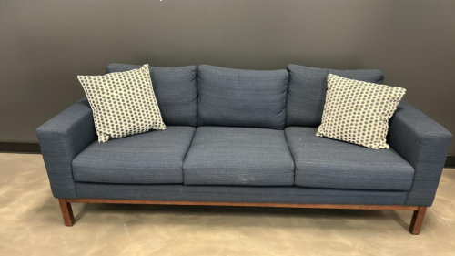 (1) BLUE OFFICE COUCH WITH (2) WHITE AND GRAY PILLOWS