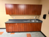 MODULAR BREAKROOM CABINETRY SET WITH LAMINATE COUNTERTOP, DOUBLE-BASIN STAINLESS STEEL SINK, GOOSENECK FAUCET, UPPER WALL CABINETS, BASE CABINETS, DRAWERS, AND INTEGRATED BACKSPLASH