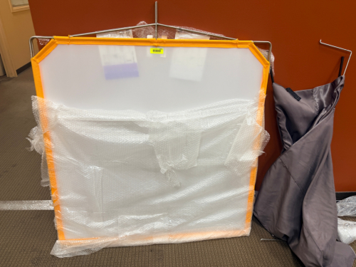 FOLDING LIGHT DIFFUSION PANEL WITH METAL FRAME, FABRIC CARRY BAG, AND DISASSEMBLED SUPPORT POLES.