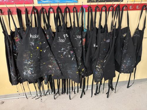 (1) LARGE LOT OF PAINTING APRONS WITH HANGING RACK