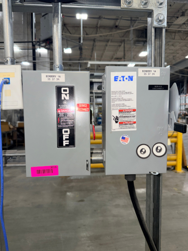 SERVICE DISCONNECT SWITCHES MOUNTED ON STRUT SUPPORT FRAME WITH ANALOG WALL CLOCK. INCLUDES (1) GE GENERAL DUTY SAFETY SWITCH, (1) EATON GENERAL DUTY SAFETY SWITCH, GALVANIZED UNISTRUT FRAME