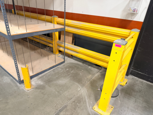 L SHAPED HEAVY-DUTY STEEL WAREHOUSE SAFETY GUARD RAIL BARRIER SYSTEM. INCLUDES (2) END GUARD RAIL SECTIONS WITH STEEL POSTS, HORIZONTAL RAILS, AND FLOOR MOUNTING BASE PLATES.