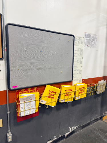 WALL MOUNTED PUSH PIN BOARD AND SAFETY BINDERS.