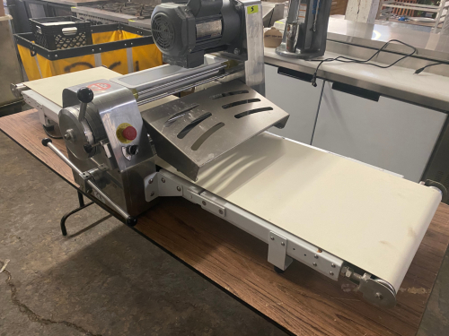 STAINLESS STEEL ELECTRIC TABLETOP DOUGH SHEETER WITH REVERSIBLE CONVEYOR BELTS, ADJUSTABLE ROLLER THICKNESS, EMERGENCY STOP BUTTON, AND FOLDING CONVEYOR TABLES.