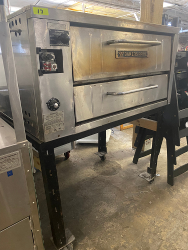 BAKERS PRIDE SINGLE DECK GAS PIZZA OVEN. STAINLESS STEEL EXTERIOR, STONE DECKS, INDEPENDENT DOORS, AND ADJUSTABLE TOP/BOTTOM HEAT CONTROL. UNIT IS MOUNTED ON A STEEL STAND WITH CASTERS