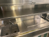 STAINLESS STEEL MOBILE CONCESSION FOOD CART WITH ENCLOSED STORAGE, OVERHEAD DISPLAY FRAME, SERVING SHELF, THREE PAN WELLS, DOUBLE BASIN HAND SINK, LOCKING CASH DRAWER, AND ROLLING CASTERS. UNIT FEATURES A STAINLESS STEEL CONSTRUCTION WITH VINYL SKIRTING - 8