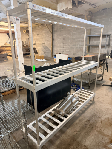 ALUMINUM FOUR-TIER HEAVY-DUTY DUNNAGE SHELVING UNIT WITH OPEN SLAT SHELVES, TUBULAR UPRIGHTS, AND ADJUSTABLE FEET. ALL-ALUMINUM CONSTRUCTION WITH WELDED SLAT-STYLE SHELVES AND FOUR VERTICAL SUPPORT POSTS.