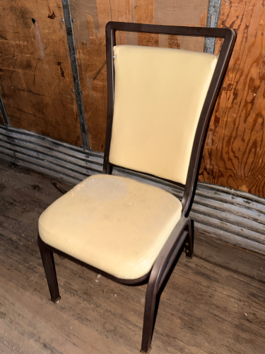 (20) METAL BANQUET STACK CHAIRS W/ TAN PADDED SEATS.