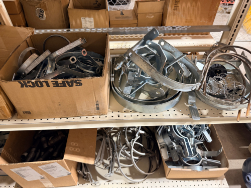 LARGE ASSORTED LOT OF INDUSTRIAL PIPE HANGERS, PIPE CLAMPS, LOOP HANGERS, RISER-STYLE CLAMPS, SUPPORT BRACKETS, THREADED HARDWARE, AND RELATED METAL PIPE-SUPPORT COMPONENTS.