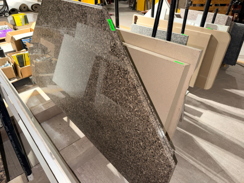 (2) POLISHED GRANITE COUNTERTOP / SLAB SECTION FEATURING A MOTTLED BROWN, TAN, BLACK, AND GRAY NATURAL STONE PATTERN. FABRICATED RECTANGULAR SECTION WITH POLISHED FACE AND FINISHED EDGES.