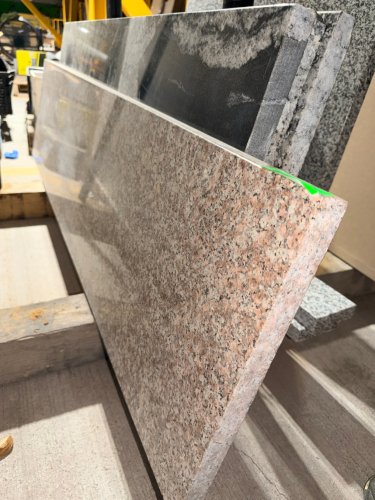 (1) POLISHED GRANITE COUNTERTOP / STONE SLAB WITH PINK, GRAY, BLACK, AND CREAM SPECKLED NATURAL STONE PATTERN. RECTANGULAR CUT PIECE WITH POLISHED FACE AND FINISHED EDGES.