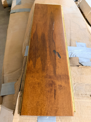 (4) BOXES OF ENGINEERED HARDWOOD FLOORING CONSISTING OF TONGUE-AND-GROOVE PLANKS WITH A MEDIUM BROWN WOOD-GRAIN FINISH.