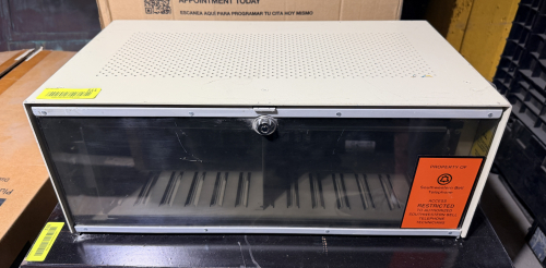 VINTAGE TELEPHONE EQUIPMENT CONNECTION OR TERMINAL CABINET WITH METAL ENCLOSURE, VENTILATED TOP, LOCKING SMOKED TRANSPARENT FRONT COVER, AND MULTIPLE INTERNAL PLUG-IN CONNECTION MODULES.