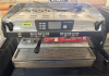 NUOVA SIMONELLI TWO-GROUP AUTOMATIC ESPRESSO MACHINE WITH DUAL GROUP HEADS, PROGRAMMABLE VOLUMETRIC BREW CONTROLS, DIGITAL DISPLAY, DUAL STEAM WANDS, HOT WATER DISPENSER, PRESSURE GAUGE, CUP WARMING SURFACE, AND STAINLESS STEEL DRIP TRAY.