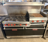 VULCAN NATURAL GAS RESTAURANT RANGE WITH SIX OPEN-TOP BURNERS, 24" GRIDDLE, TWO STANDARD OVEN BASES, HEAVY CAST-IRON BURNER GRATES, STAINLESS STEEL FRONT AND BACKSPLASH, RED BURNER CONTROLS, OVEN RACKS, AND DUAL OVEN DOORS.